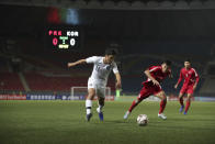 In this photo provided by the Korea Football Association, South Korea's Hwang Hee-chan, left, fights for the ball against North Korea's Kim Chol Bom during their Asian zone Group H qualifying soccer match for the 2022 World Cup at Kim Il Sung Stadium in Pyongyang, North Korea, Tuesday, Oct. 15, 2019. (The Korea Football Association via AP)