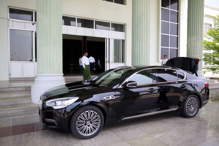 Men stand near the car of senior Union Solidarity and Development Party (USDP) adviser Aung Thaung at the party's office in Naypyitaw May 14, 2015. REUTERS/Soe Zeya Tun