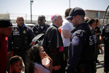 A Honduran migrant talks to a U.S. Border Protection officer at the El Paso del Norte international border crossing bridge to help them to ask for asylum in El Paso, Texas, U.S. as seen from Ciudad Juarez
