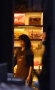 A female hostage stands by the front entrance of the cafe as she turns the lights off in the Sydney central business district on December 15, 2014