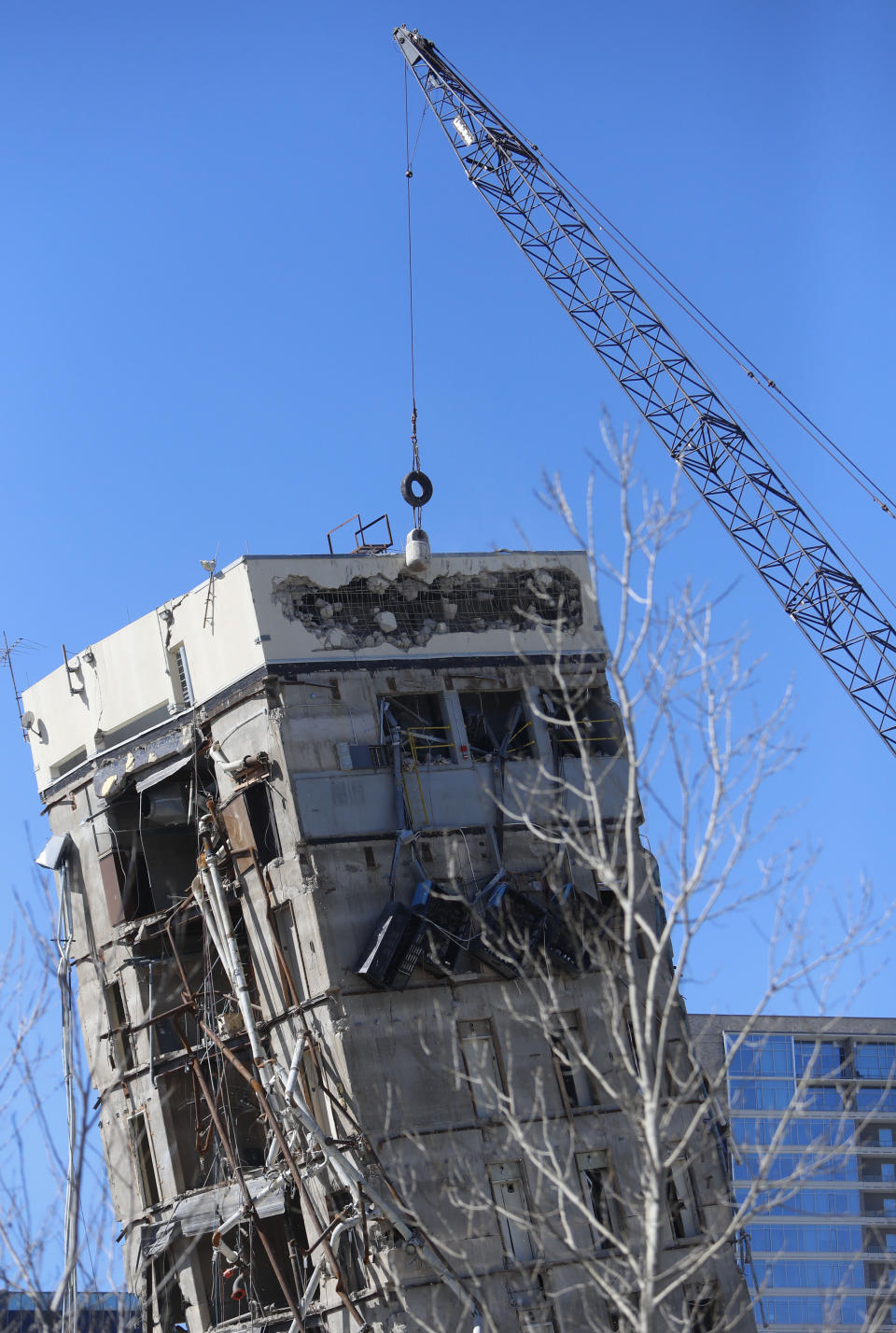 A wrecking ball smashes against the "Leaning Tower of Dallas" north of downtown Dallas, Monday, Feb. 24, 2020. The still-standing structure is part of the 11-story former Affiliated Computer Services building that found a second life online after a Feb. 16 implosion attempt. The company that engineered the blast said some explosives did not go off. (AP Photo/LM Otero)