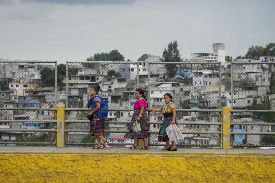 Women walk over Naranjo river bridge, as rescuers search for survivors after homes of the "Dios es fiel," or God is Loyal shanty town were swept away overnight by a swollen Naranjo River, on the outskirts of Guatemala City, Monday, Sept. 25, 2023. (AP Photo/Moises Castillo)