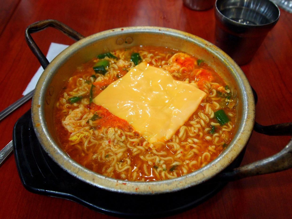 a pot of ramen with cheese melting