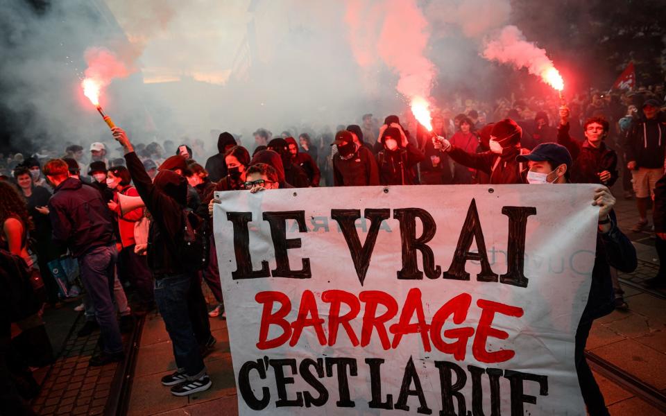 Protesters hold a banner reading "The real barrier is the road" during a demonstration following the announcement of the first results