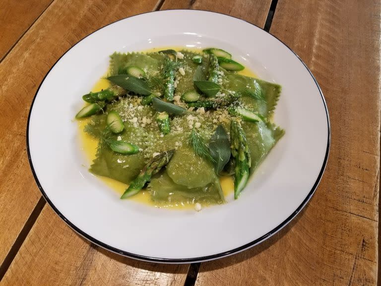 Plato de ravioles verdes de ricota, parmesano, hierbas y limón con espárragos al fuego