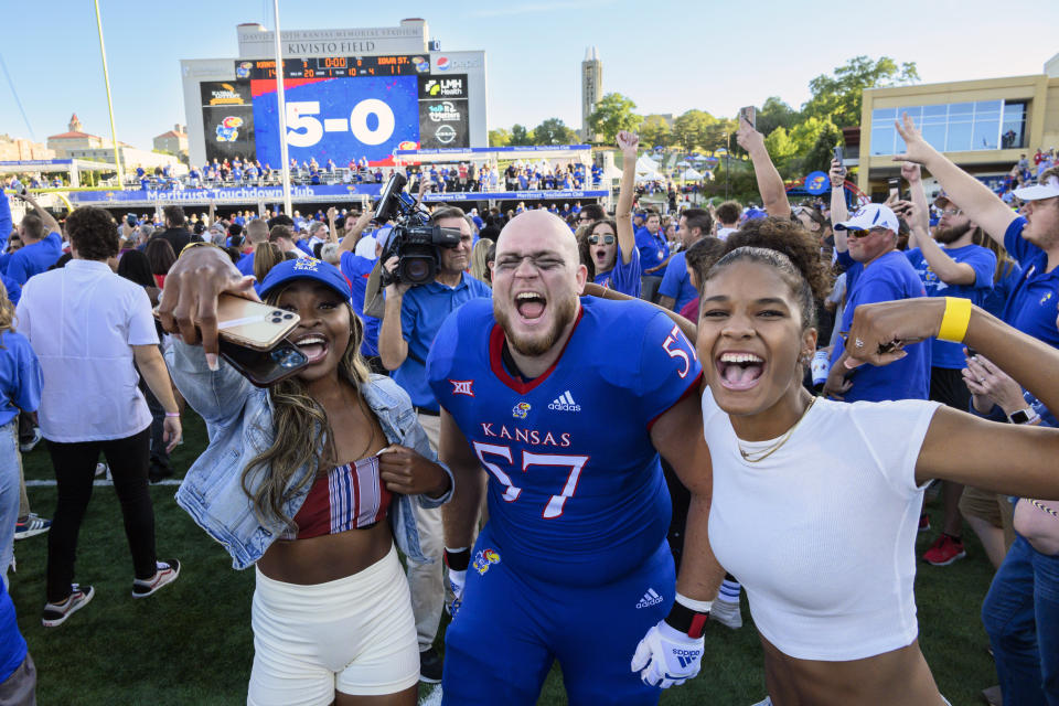 Kansas offensive lineman Hank Kelly (57) and fans celebrate on the field after they beat Iowa State to go 5-0 after an NCAA college football game, Saturday, Oct. 1, 2022, in Lawrence, Kan. (AP Reed/Hoffmann)