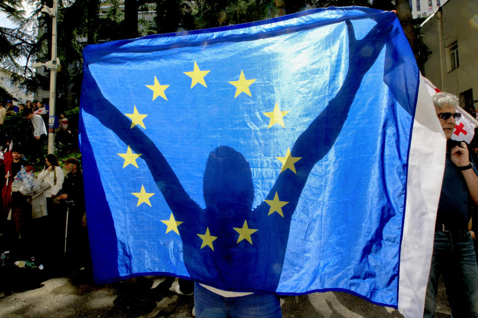 A demonstrator holds a EU flag during an opposition protest against the foreign influence bill at the Parliamentary building in Tbilisi, Georgia, Tuesday, May 28, 2024. (AP Photo/Shakh Aivazov)