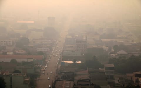 A general view over smoke from fires in teh Amazon rainforest that cover the city of Porto Velho - Credit: Rex