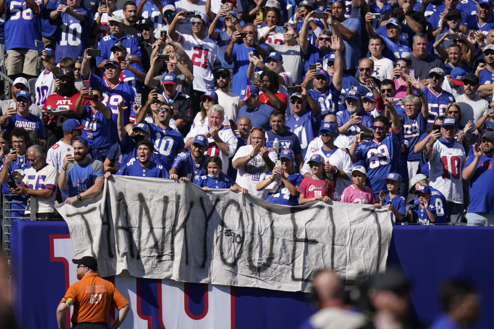 Fans honor former New York Giants quarterback Eli Manning as he addresses the crowd during a ceremony to retire his jersey number 10 and celebrate his tenure with the team during half-time in an NFL football game against the Atlanta Falcons, Sunday, Sept. 26, 2021, in East Rutherford, N.J. (AP Photo/Seth Wenig)