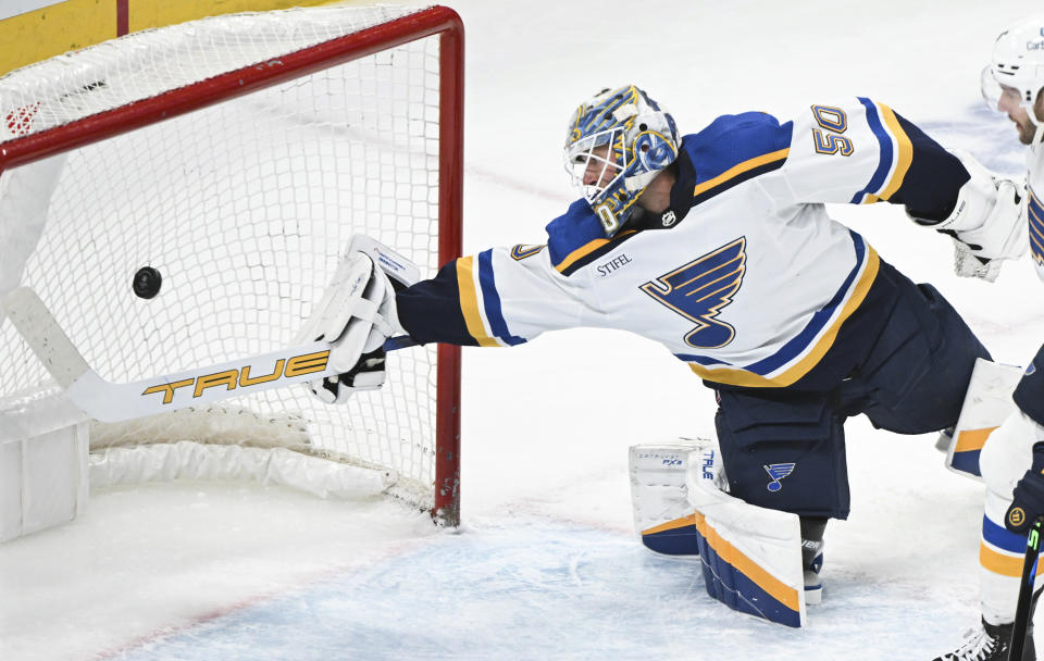 St. Louis Blues goaltender Jordan Binnington is scored on by Montreal Canadiens' Nick Suzuki during first period NHL hockey action in Montreal, Sunday, Feb. 11, 2024. (Graham Hughes/The Canadian Press via AP)