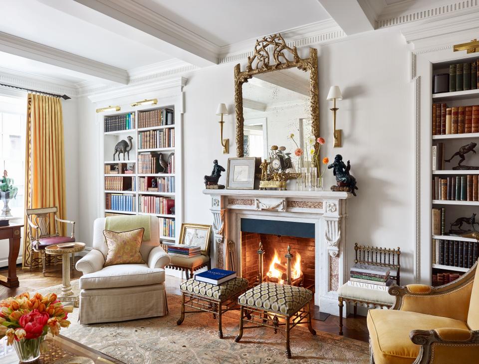 “Decorating a room is like making a great salad,” designer Bunny Williams says. “You want interesting ingredients. The little black theater chairs in my living room are not comfortable, but they make me smile. So I put them by the fireplace and stack books on them.” Over mantel, 19th-century gilded faux-bois mirror; antique English stools and theater chairs; custom armchair by Schneller in a Claremont fabric; rug from Doris Leslie Blau.