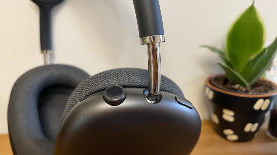 Close up of digital crown control on Apple AirPods Max headphones with a small house plant in background