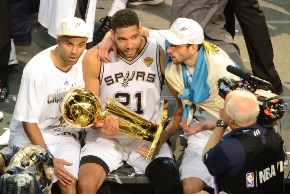 San Antonio Spurs guard Tony Parker (9) forward Tim Duncan (21) and Manu Ginobili (20) celebrate with the Larry O'Brien trophy after defeating the Miami Heat in game five of the 2014 NBA Finals at AT&T Center. The Spurs defeated the Heat 104-87 to win the NBA Finals.