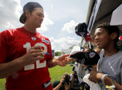 New England Patriots quarterback Tom Brady (L) signs an autograph for a fan at the end of the morning practice session during the first day of their NFL training camp in Foxborough, Massachusetts July 28, 2011. REUTERS/Brian Snyder