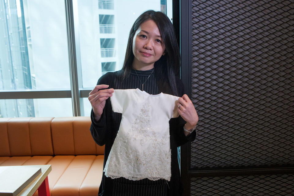 Insurance agent Christy Liew, 34, poses with a baby gown that she sewed. Liew volunteers with Angel Hearts Singapore, which repurposes used wedding gowns into gowns for deceased babies. PHOTO: Dhany Osman/Yahoo News Singapore 