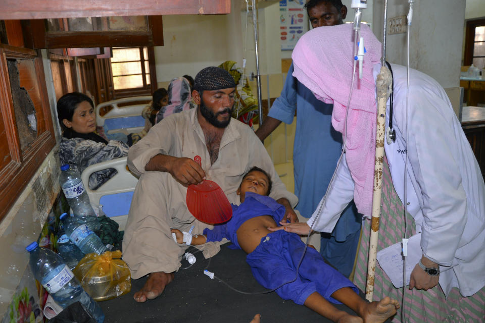 A doctor checks a child, who is suffering from gastroenteritis due to hot weather, at a hospital in Hyderabad, Pakistan, Thursday, May 23, 2024. Doctors were treating hundreds of victims of heatstroke at various hospitals across Pakistan on Thursday after an intense spell of the heat wave began in the country, and the mercury rose to above normal due to climate change, officials said. (AP Photo/Pervez Masih)