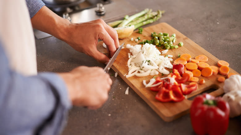 Cutting fresh vegetables on a wooden board