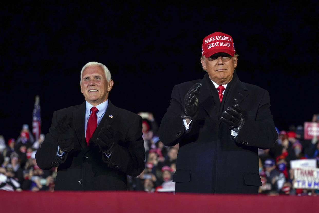 Then-President Donald Trump arrives for a campaign rally at Gerald R. Ford International Airport, Nov. 2, 2020, in Grand Rapids, Mich., with then-Vice President Mike Pence. (AP Photo/Evan Vucci)