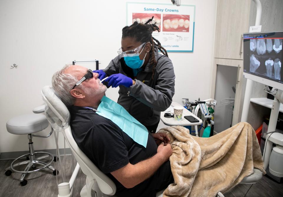 Bianca Jean, lead dental assistant at Dentists of Fort Myers, takes an impression of Clay Chabot's teeth on Saturday, Aug. 19, 2023, in Fort Myers. Chabot is being helped along with five other people as a part of the practice's annual Serve Day.