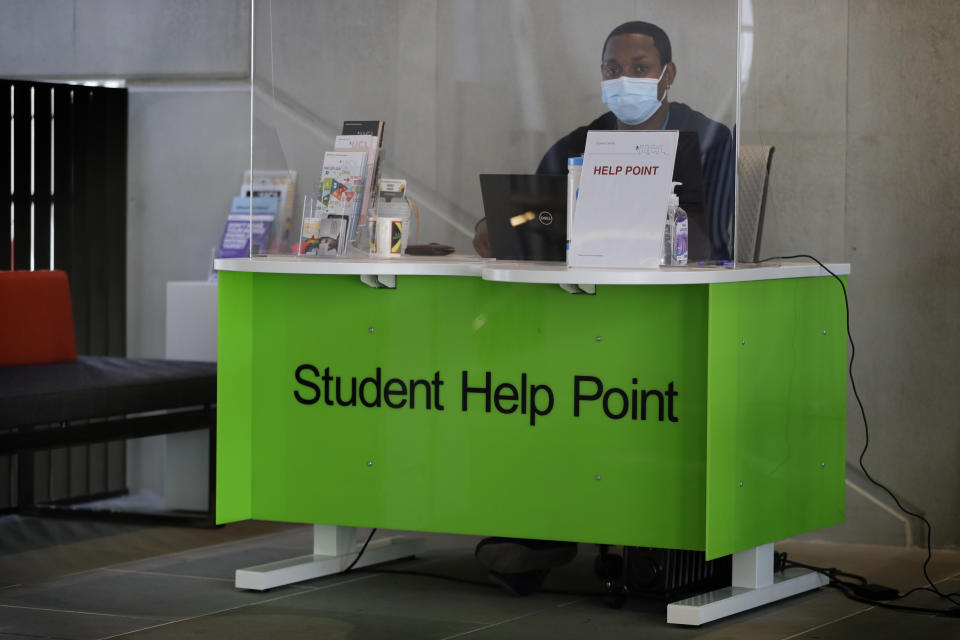 A student help point is set up behind a screen at UCL (University College London) in London, Thursday, Sept. 17, 2020. In the UK, most universities do not begin their fall terms until late September or early October, and are readying big changes. At University College London, only a quarter of the buildings will be occupied at one time. Teaching spaces will incorporate social distancing and everyone must wear face-masks. (AP Photo/Kirsty Wigglesworth)