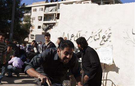 A man reacts fearing sniper fire at a Free Syrian Army checkpoint in Aleppo's Bustan al-Qasr, October 26, 2013. REUTERS/Mahmoud Hassano