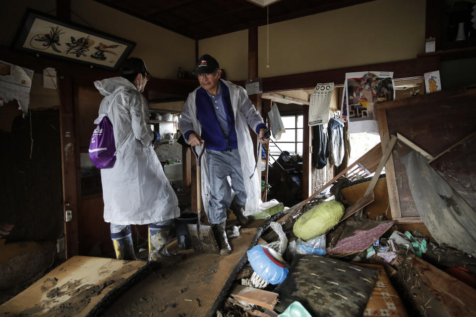 Toshio Yonezawa, 73, center, surveys his home with son, Yusuke, after Typhoon Hagibis passed through his neighborhood, Oct. 15, 2019, in Nagano, Japan. (Photo: Jae C. Hong/AP)