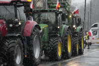 Farmers driving in a heavy-duty tractor into the western city of Poznan as part of a nationwide farmer protest against European Union's agrarian policy and imports of cheap Ukraine produce, which, they say, are undercutting their livelihoods, in Poznan, Poland, on Friday Feb. 9, 2024. (AP Photo/Czarek Sokolowski)