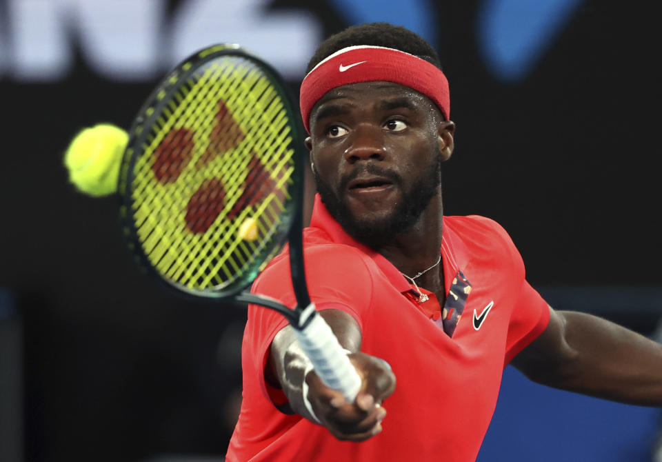 FILE - In this Tuesday, Jan. 21, 2020 file photo, Frances Tiafoe of the United States makes a backhand return to Russia's Daniil Medvedev during their first round singles match at the Australian Open tennis championship in Melbourne, Australia. Frances Tiafoe has tested positive for the coronavirus and withdrawn from the All-American Team Cup tennis tournament. Tiafoe was scheduled to face Tennys Sandgren on Saturday, July 4, 2020 in the weekend tournament involving eight top American men’s players at Life Time Fitness in Peachtree Corners.(AP Photo/Lee Jin-man, File)