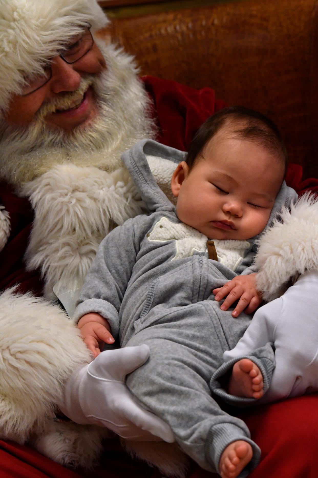 Four-month-old Ryusuke Thaxton dozes in Santa Claus' lap at the Abilene Zoo in Dec. 2018.