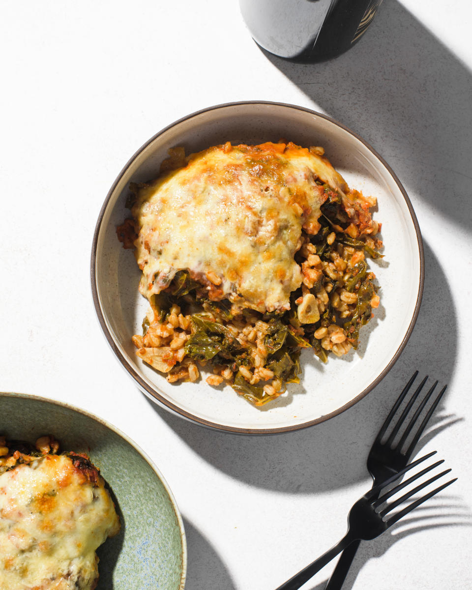 This image released by Milk Street shows a recipe for cheese baked farro with kale and tomatoes. (Milk Street via AP)