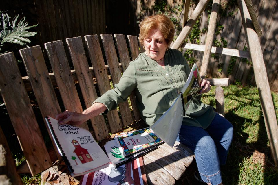 Mary Gerardi, a woman who substituted at Buck Lake Elementary for 15 years but has since stopped due to the pandemic, sits on a swing in her backyard as she flips through books she made with her students Friday, Oct. 1, 2021. 