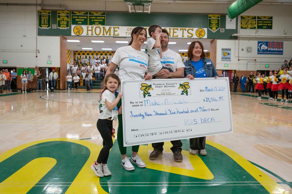 Cash Blanchfield and his family are presented with a check for money raised by Pueblo County High students and staff as part of "Wish Week" where the funds raised are donated to the Make-a-Wish Foundation.