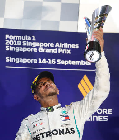 Motor Racing - Formula One - F1 Singapore Grand Prix 2018 - Singapore - September 16, 2018 Mercedes' Lewis Hamilton celebrates on theÊpodiumÊafter winning the race REUTERS/Kim Hong-Ji