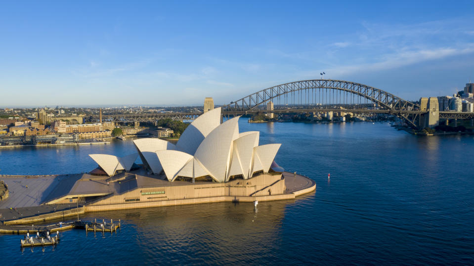 SYDNEY, AUSTRALIA - APRIL 18: Sunrise at the Sydney Opera House as seen from a drone on April 18, 2020 in Sydney, Australia. Prime Minister Scott Morrison on Thursday flagged that current restrictions in place to stop the spread of COVID-19 could be lifted in four weeks, should Australia's infection rate continue to flatten. Currently, all non-essential business are closed and strict social distancing rules are in place, while public gatherings are limited to two people. New South Wales and Victoria have enacted additional lockdown measures to allow police the power to fine people who breach the two-person outdoor gathering limit or leave their homes without a reasonable excuse. Queensland, Western Australia, South Australia, Tasmania and the Northern Territory have all closed their borders to non-essential travellers and international arrivals into Australia are being sent to mandatory quarantine in hotels for 14 days. (Photo by James D. Morgan/Getty Images)