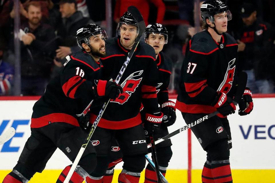 Carolina Hurricanes’ Vincent Trocheck (16) is congratulated on his goal by Tony DeAngelo, center, with teammates Sebastian Aho (20) and Andrei Svechnikov (37) nearby during the first period of an NHL hockey game against the New York Rangers in Raleigh, N.C., Friday, Jan. 21, 2022. (AP Photo/Karl B DeBlaker)