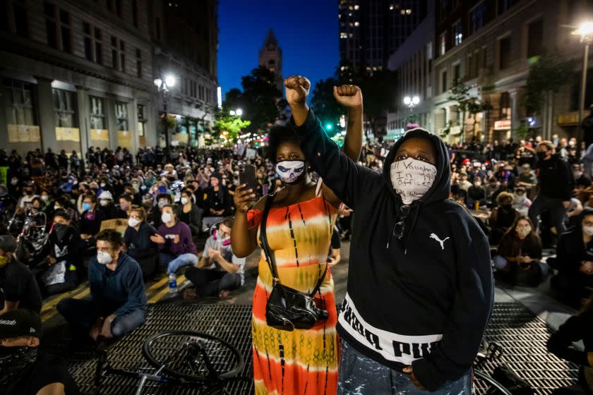 Demonstrators raise their fists during a "Sit Out the Curfew" protest against the death of George Floyd who died on May 25 in Minneapolis whilst in police custody, along a street in Oakland, California on June 3, 2020. - US protesters welcomed new charges against Minneapolis officers in the killing of African-American man George Floyd -- but thousands still marched in cities across the country for a ninth straight night, chanting against racism and police brutality. (Photo by Philip Pacheco / AFP) (Photo by PHILIP PACHECO/AFP via Getty Images)