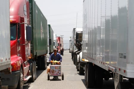 A street vendor is seen among trucks waiting in queue for border customs control at the Otay border crossing in Tijuana