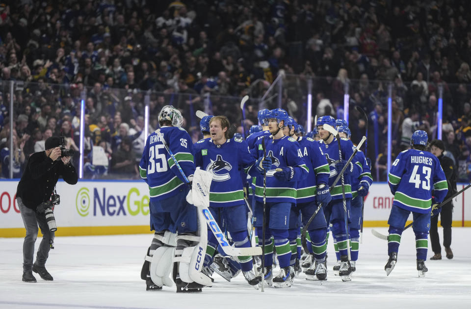 Vancouver Canucks' Brock Boeser, third from left, celebrates after his winning goal with goalie Thatcher Demko (35) during overtime NHL hockey game action against the Boston Bruins in Vancouver, British Columbia, Saturday, Feb. 24, 2024. (Darryl Dyck/The Canadian Press via AP)