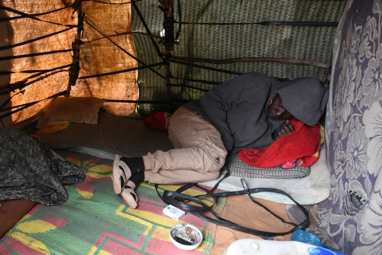 A migrant rests inside a makeshift tent at a camp in Jebeniana (FETHI BELAID)