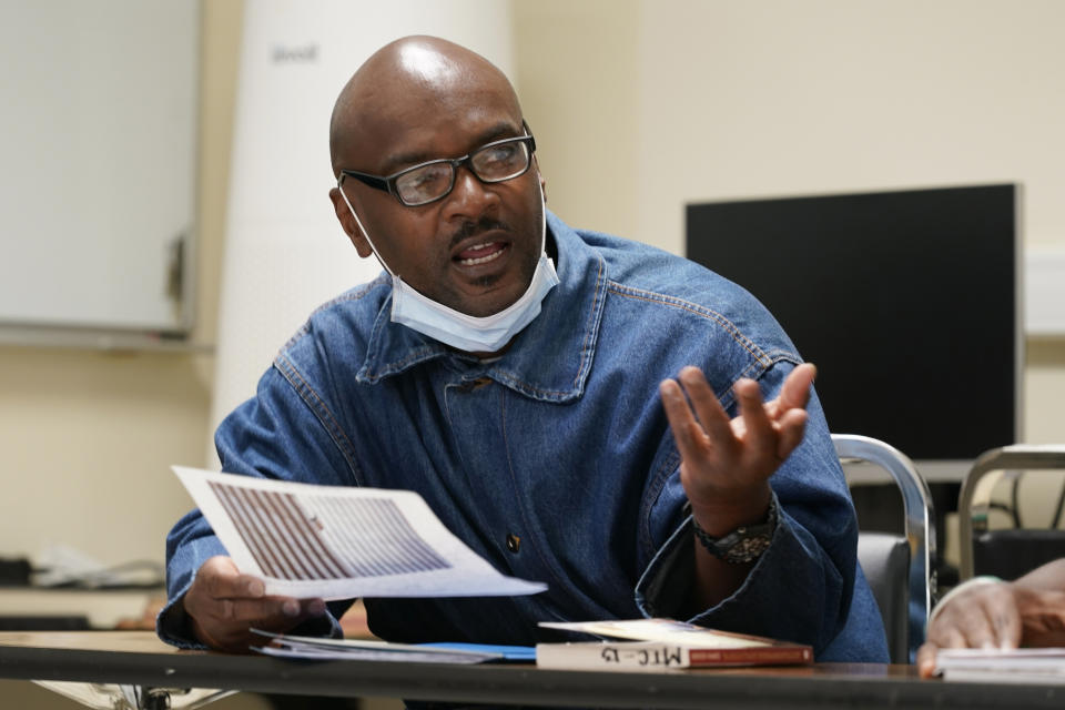 Incarcerated student Derry Brown gestures while speaking during a Mount Tamalpais College English class called Cosmopolitan Fictions at San Quentin State Prison April 12, 2022, in San Quentin, Calif. The community college, the first in California with a campus inside a prison, is the latest addition to San Quentin's numerous rehabilitation programs that have made it a desired destination for inmates throughout the state. "I wish I had learned this way coming up, instead I was in special ed my whole life," Brown shared with his fellow students, who were discussing The Reluctant Fundamentalist, a novel by Mohsin Hamid. (AP Photo/Eric Risberg)