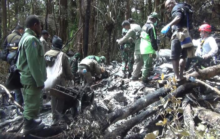 Indonesian rescuers search through wreckage of the Trigana Air ATR 42-300 twin-turboprop plane at the crash site in the mountainous area of Oksibil on August 18, 2015 (AFP Photo/STR)