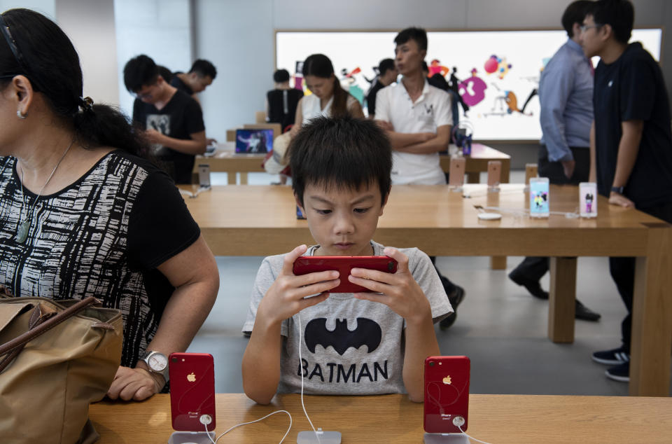 A boy plays a game on an IPhone at the Apple Store in Causeway Bay, Hong Kong. (Photo: Miguel Candela/SOPA Images/LightRocket via Getty Images)