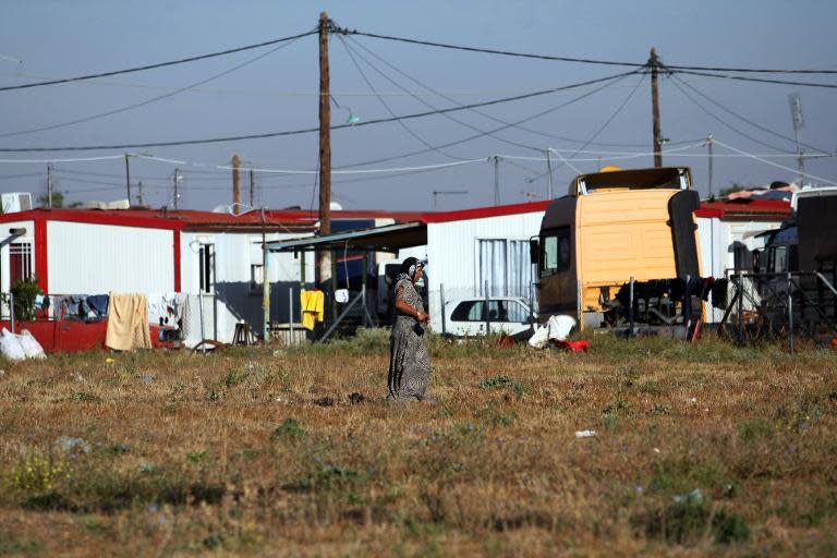 A Roma woman walks next to a Roma settlement in Farsala, central Greece, on October 21, 2013, where a four-year-old girl was found living with a Roma couple