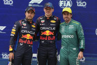 Qualifying winner Red Bull driver Max Verstappen, centre, of the Netherlands stands with second placed teammate Sergio Perez, left, and third placed Aston Martin driver Fernando Alonso, right, of Spain at the Chinese Formula One Grand Prix at the Shanghai International Circuit, Shanghai, China, Saturday, April 20, 2024. (AP Photo/Andy Wong)