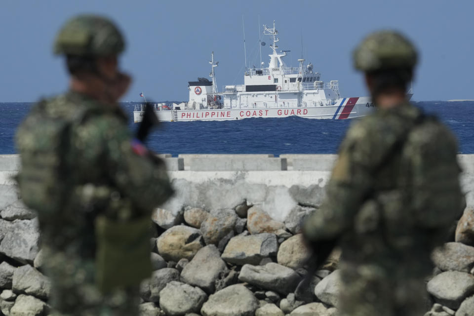 FILE - Philippine troops watches a Philippine coast guard ship as they secure an area at the Philippine-occupied Thitu island, locally called Pag-asa island, on Friday, Dec. 1, 2023 at the disputed South China Sea. For the first time, China has publicized what it claims is an unwritten 2016 agreement with the Philippines over access to South China Sea islands. (AP Photo/Aaron Favila, File)