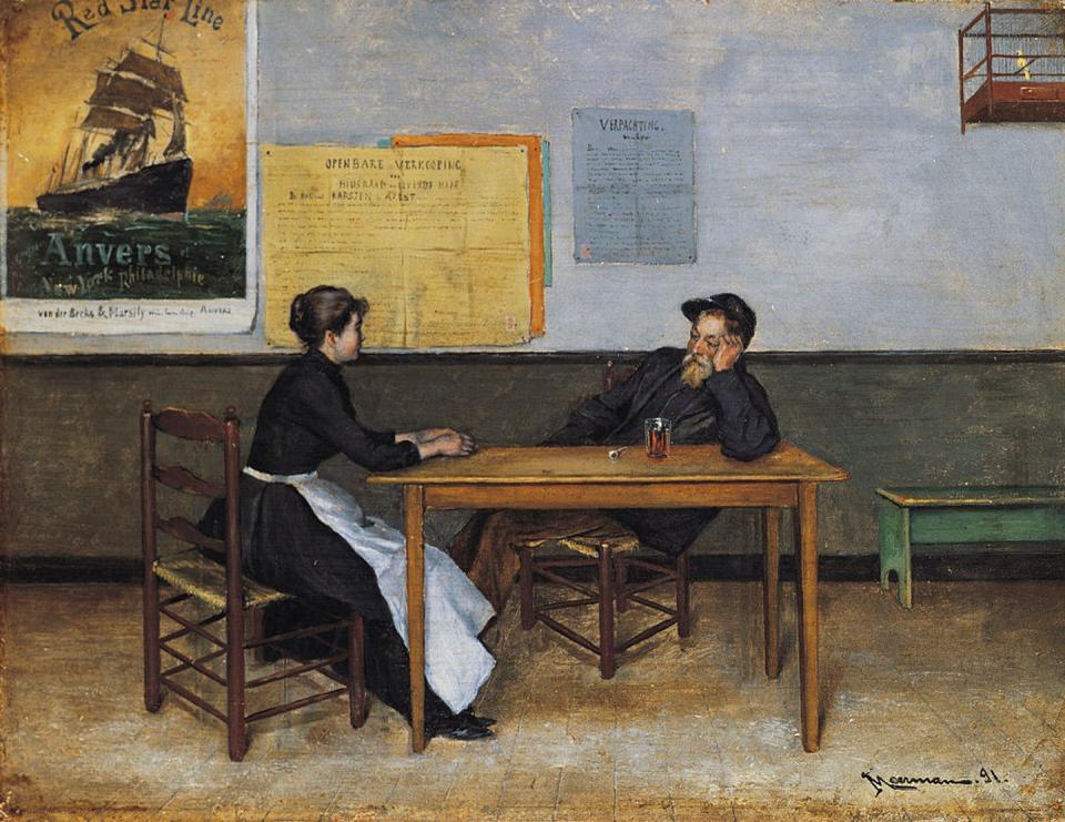 Woman and man seated at table talk to one another.