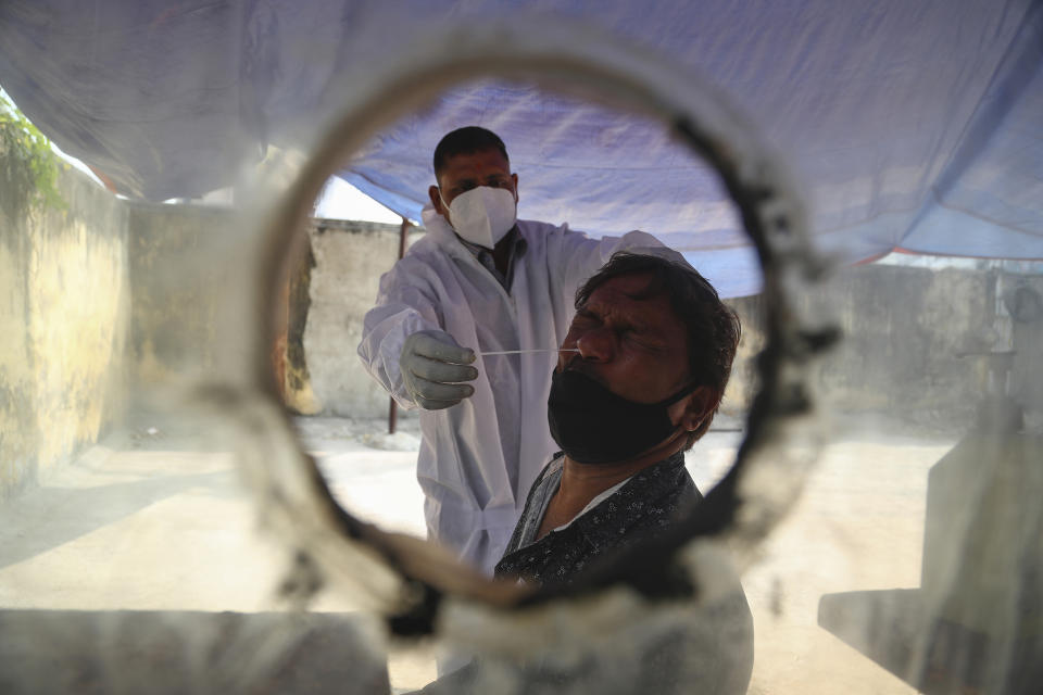 A health worker takes a nasal swab sample at a COVID-19 testing center in Hyderabad, India, Saturday, Jan. 2, 2021. (AP Photo/Mahesh Kumar A.)