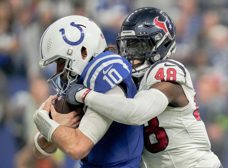 Houston Texans linebacker Christian Harris (48) brings down Indianapolis Colts quarterback Gardner Minshew II (10) on Saturday, Jan. 6, 2024, during a game against the Houston Texans at Lucas Oil Stadium in Indianapolis.