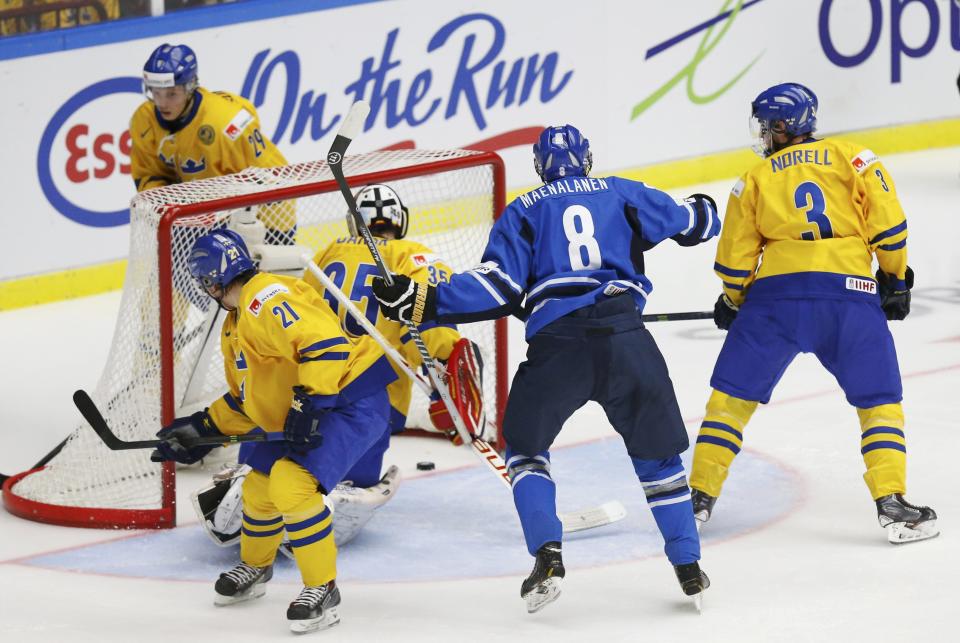 Finland's Saku Maenlanen (8) reacts after scoring on Sweden's goalie Oscar Dansk as Sweden's Filip Sandberg (L) and Robin Norell (R) watch the puck during the second period of their IIHF World Junior Championship gold medal ice hockey game in Malmo, Sweden, January 5, 2014. REUTERS/Alexander Demianchuk (SWEDEN - Tags: SPORT ICE HOCKEY)