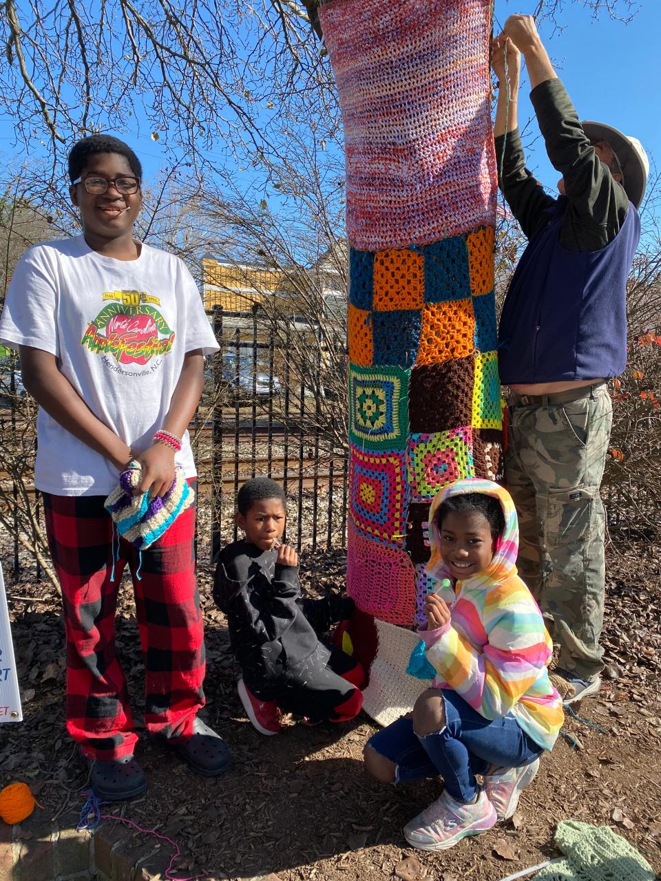 People participate in STEAP's CommuniTREES Yarn Art Project. The art is on display through early April.